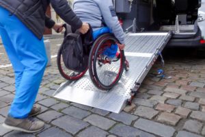 Person in wheelchair pushed into wheelchair van