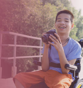 Child in wheelchair with camera