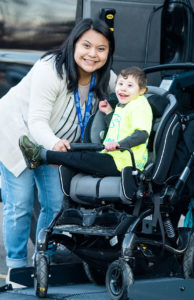 Special child in wheelchair posing for camera outside his wheelchair van